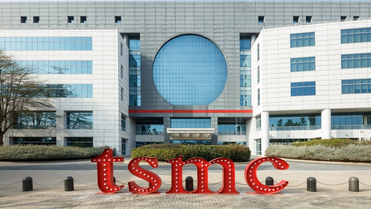 The iconic TSMC wordmark is seen in front of a fabrication facility.